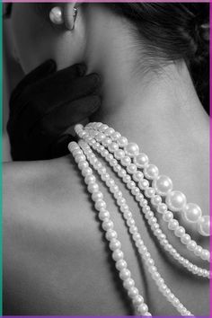 the back of a woman's neck with pearls on it