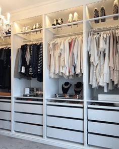 an organized closet with clothes and shoes on the shelves, lights hanging from the ceiling