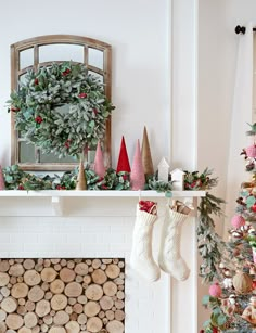 a decorated christmas tree in front of a fireplace with stockings hanging from the mantel