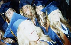 a group of women in graduation caps and gowns posing for a photo with each other