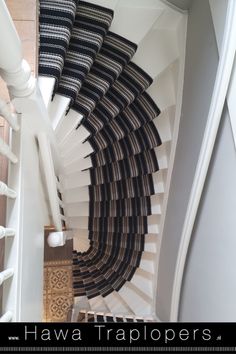 a spiral staircase with black and white carpet