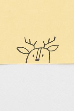 a piece of yellow paper with a drawing of a deer on it's face