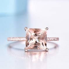 a pink diamond ring sitting on top of a table