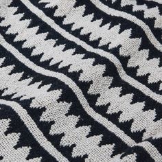 a black and white knitted blanket is laying on the floor