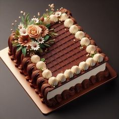 a chocolate cake decorated with flowers and leaves