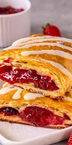 two croissants on a plate with strawberries in the background