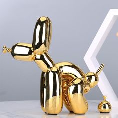 a golden dog statue sitting on top of a white table