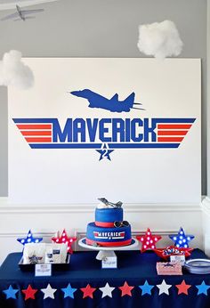 a blue table topped with a cake covered in red, white and blue frosting