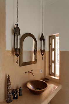 a bathroom with a sink, mirror and hanging lights