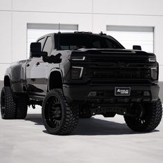 a large black truck parked in front of a building