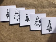 five cards with black and white trees on them