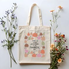 a tote bag sitting on top of a table next to flowers