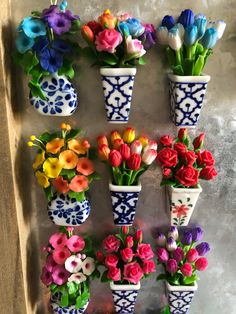 colorful flowers are arranged in blue and white vases