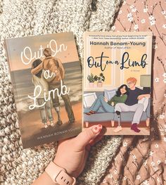 two books sitting on top of a bed next to each other in front of a blanket