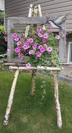 an old wooden chair with flowers growing out of it's back legs in front of a house