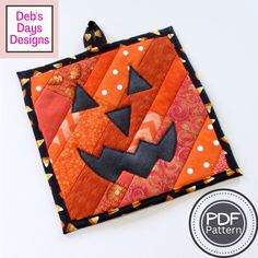 an orange and black patchwork quilt with a jack - o'- lantern on it