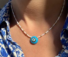 A handmade Evil Eye Necklace that is made from white glass beads, gold metal parts and a really special round evil eye that is made from light blue enamel. I have created this necklace at 39 cm length and it's slightly adjustable with the extension chain at the joined edges. Find it only at Christina Christi Store. 👉  My Women Necklaces Collection: https://etsy.me/2G3pmJD 👉 Express Shipping: https://etsy.me/3ikUnOM MATERIALS - White Beads from Glass. - Metal parts in Gold Color. - Evil Eye is White Necklaces With Tiny Beads, White Round Necklaces With Tiny Beads, White Necklaces With Tiny Round Beads, Handmade White Amulet Style Beaded Necklaces, Bohemian White Beaded Necklace With Evil Eye, White Bohemian Necklace With Evil Eye, Bohemian White Necklace With Evil Eye Detail, Handmade White Amulet Beaded Necklace, White Bohemian Beaded Necklace With Evil Eye