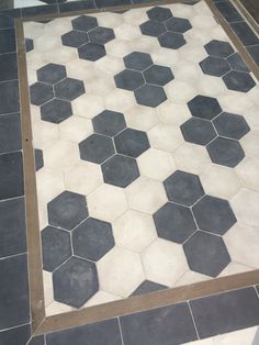 a black and white tile floor with hexagonal tiles on it's sides