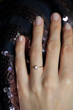 a woman's hand with a diamond ring on it