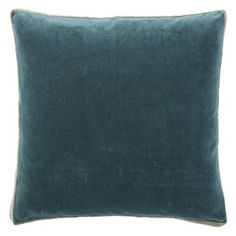 a blue velvet pillow on a white background