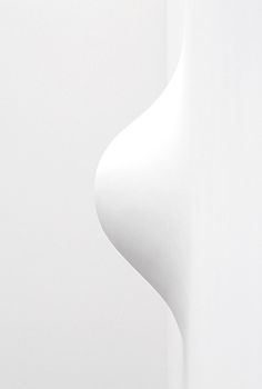 the corner of a white wall with an abstract design