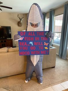 a man dressed as a shark holding a sign that says off all the fish in the sea, will you go to hobo with me?