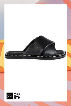 a pair of black sandals with studded straps on the bottom and an off white background