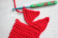 a crocheted christmas ornament next to a crochet knitting needle