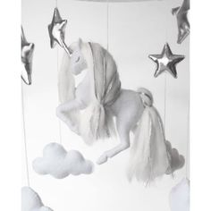 a baby crib mobile with stars and a unicorn hanging from it's side