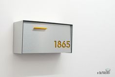 a mailbox mounted to the side of a white wall