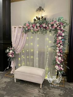 a white bench sitting next to a window covered in pink and white flowers on top of a rug