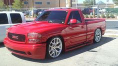 a red pick up truck parked in a parking lot