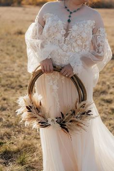 a woman in a white dress holding a basket with feathers on it and wearing a hat