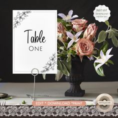 there is a vase with flowers on the table next to a sign that says table one