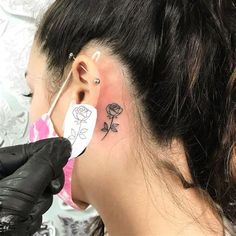 a woman with a flower behind her ear has a small tattoo on her left side