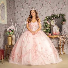 a woman in a pink ball gown posing for the camera with her hands on her hips