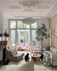 a living room filled with furniture and a cat sitting on the floor