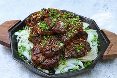 a bowl filled with meat and onions on top of a table