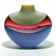 a colorful vase sitting on top of a white table