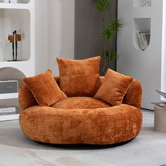 a living room with an orange round chair and white bookshelf in the background