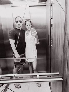 a man and woman taking a selfie in an elevator