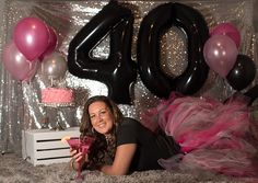 a woman laying on the floor in front of balloons and presents for her 30th birthday