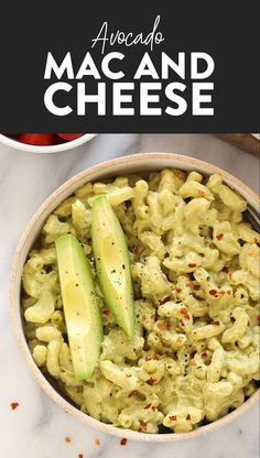 macaroni and cheese in a bowl with avocado slices on the side