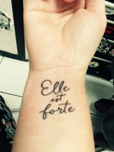 a woman's wrist tattoo with the words ele et forte on it