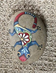 a painted rock with a lizard on it