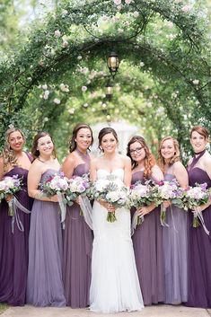 a bride and her bridal party in front of an archway at the end of their wedding day