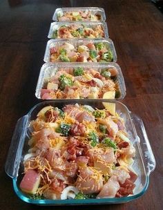 three pans filled with food sitting on top of a wooden table