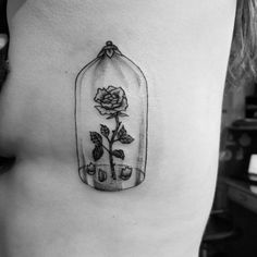 a rose in a bottle tattoo on the stomach