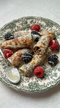 a plate topped with fruit and pastry next to a bowl of yogurt