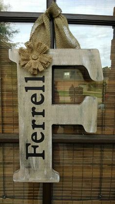 the letter e is painted white and has a burluck bow on it's front door